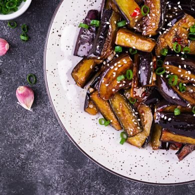 Hot spicy stew eggplant in Korean style with green onion. Aubergine saute. Vegan food. Top view